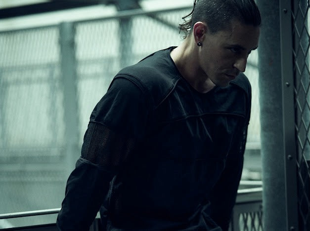 SYZMIC black panelled long-sleeve top worn by a model, showing curved chest panels.