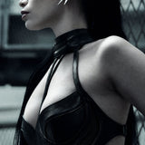 Side view of the SYZMIC EIDOS sculptural black collar harness, showing the curved collar and slender chest straps.