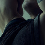 Close-up of the black SYZMIC MESH TANK TOP 211 armhole and textured mesh with the model's arm raised.