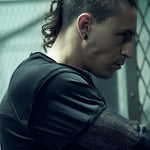 Side view of the SYZMIC black long-sleeve top with contrasting organic cotton mesh inserts.