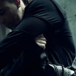 Detail of the shoulder and sleeve construction of the SYZMIC black panelled long-sleeve top.