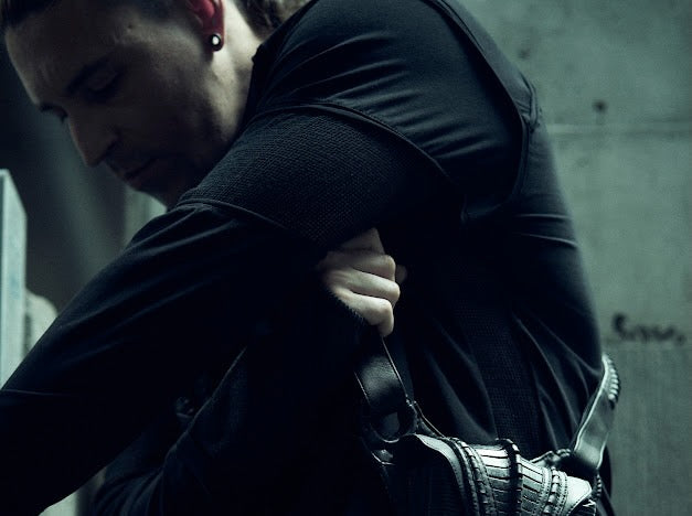 Detail of the shoulder and sleeve construction of the SYZMIC black panelled long-sleeve top.
