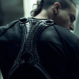 Rear view of the SYZMIC black long-sleeve top, styled beneath a separate black harness.