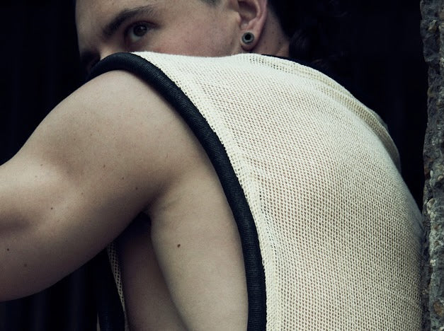 Rear view of the white/ecru SYZMIC MESH TANK TOP 212 with black tubular trim.