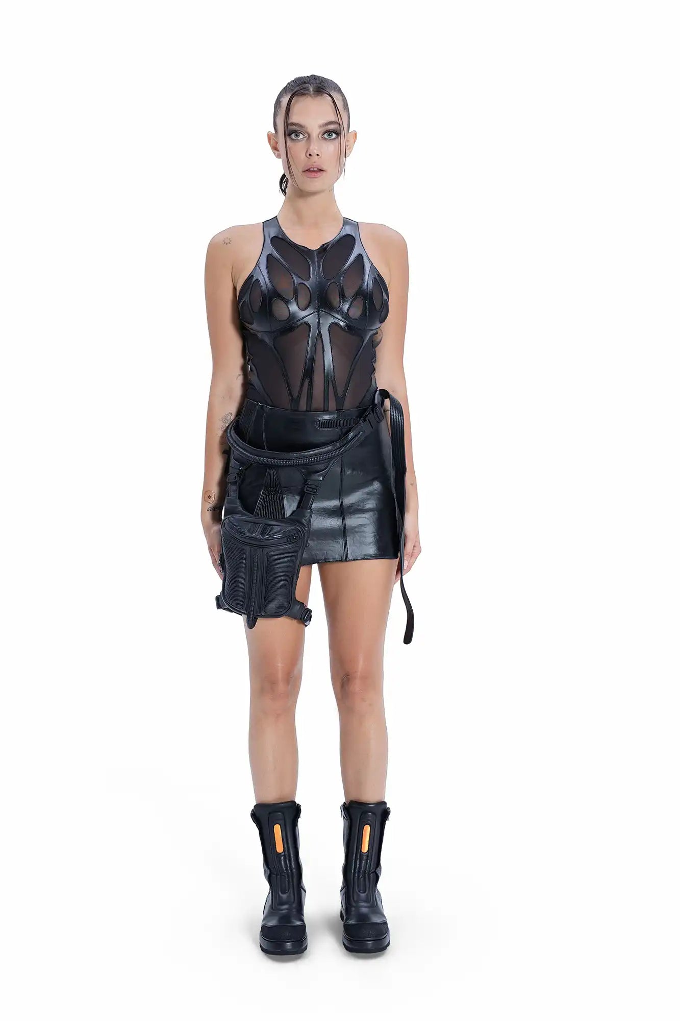 Model wearing Syzmic Studio EIDOS-201 bodysuit with leather EIDOS-101 skirt, EIDOS-401 hip and shoulder bag, styled with EIDOS-701 boots.
