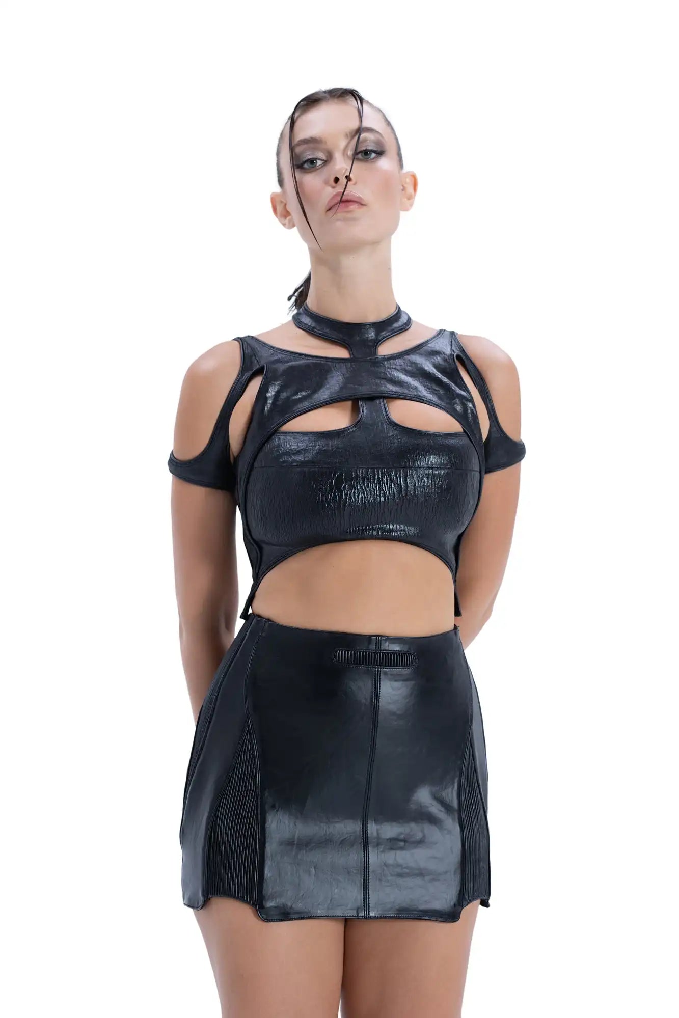 Model wearing Syzmic Studio EIDOS-204 crop top with EIDOS-101 mini skirt in black vegan leather, biomorphic avant-garde fashion.