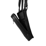 Close-up of the open main compartment of a black leather shoulder bag, illustrating the satin lining and internal pocket configuration.