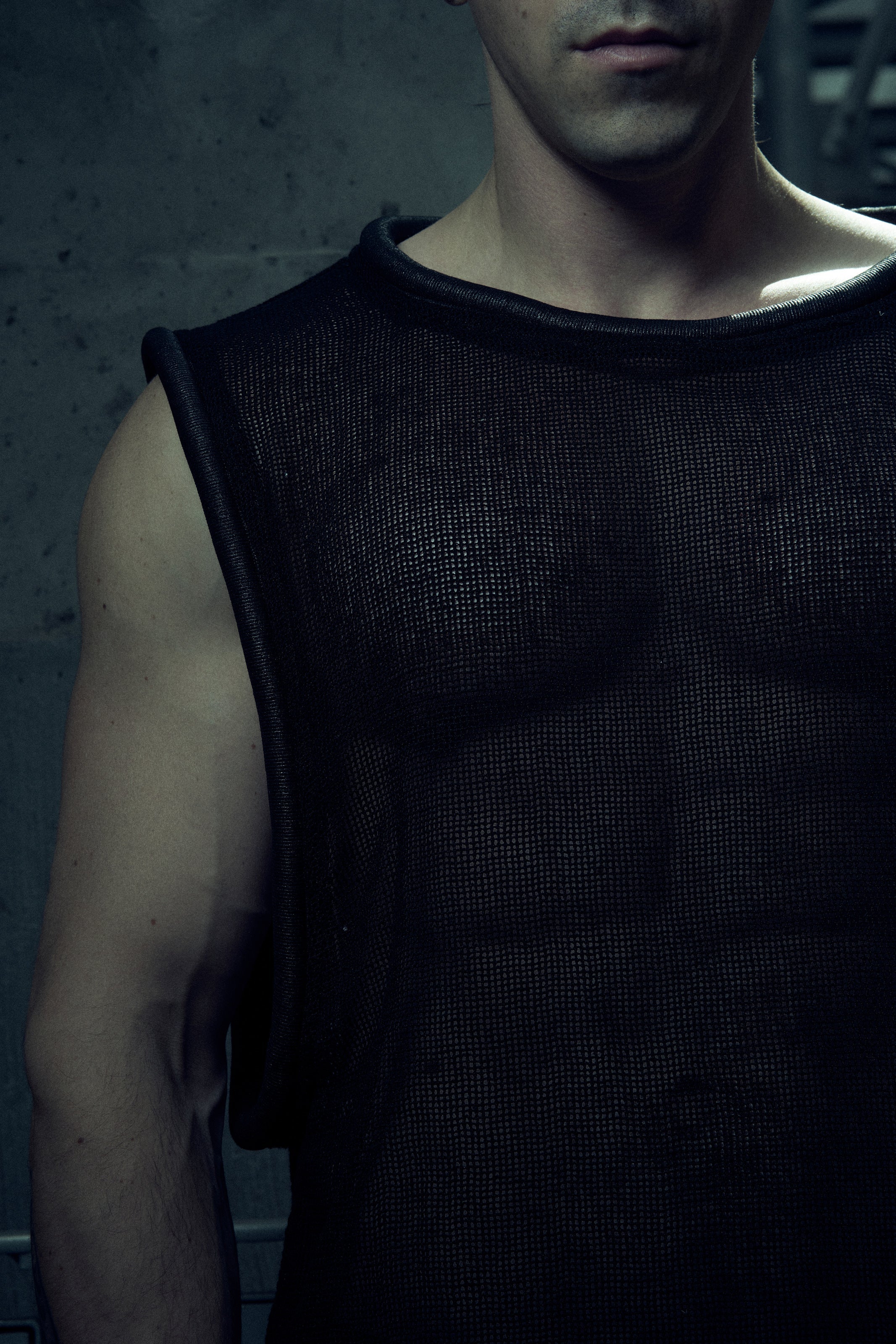 Close-up of the black EIDOS-212 tank top showing textured cotton mesh and tubular neckline.