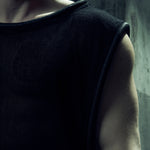 Black EIDOS-212 tank top, close-up of the shoulder and wide rounded neckline.