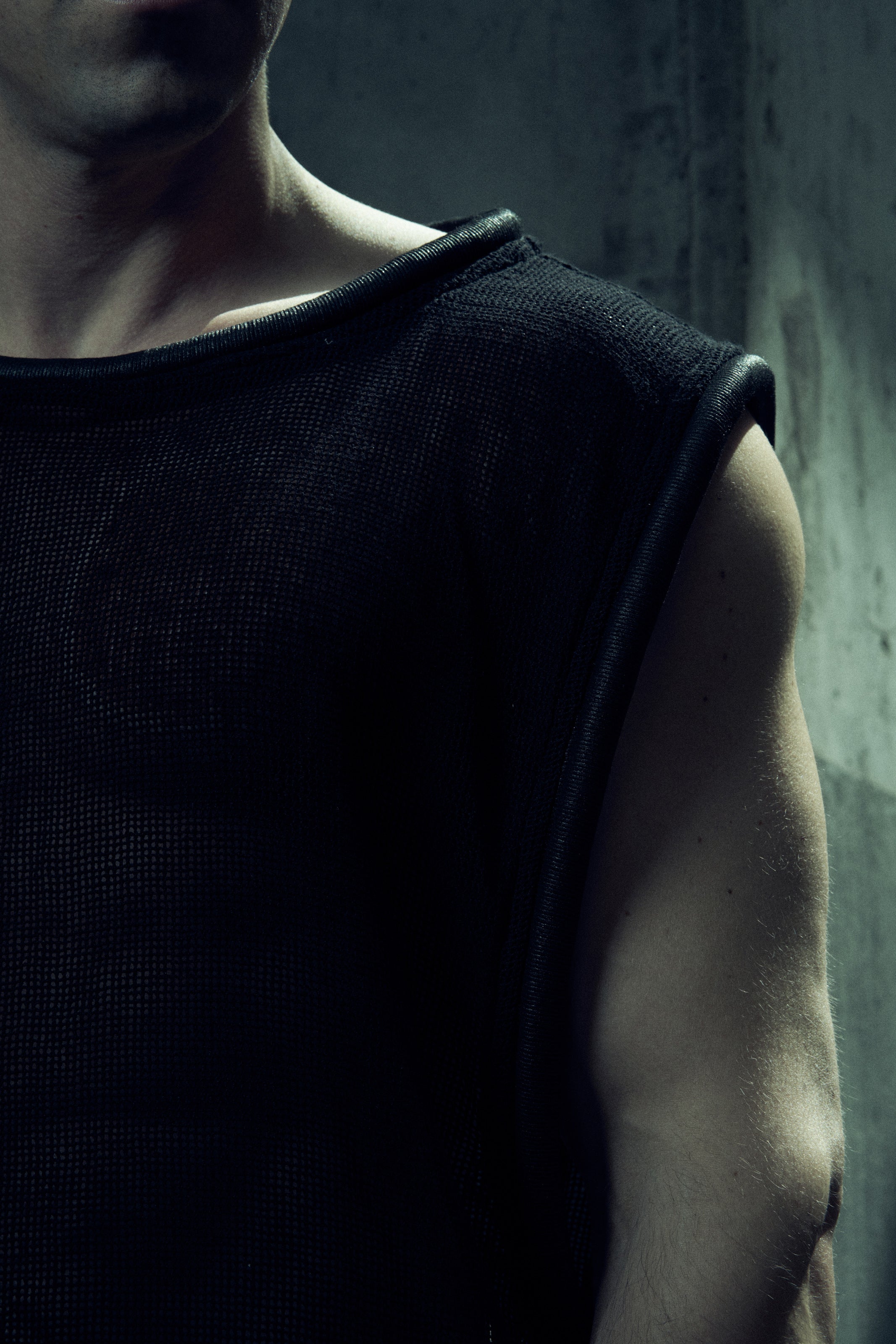 Black EIDOS-212 tank top, close-up of the shoulder and wide rounded neckline.