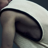 Detail of the white EIDOS-212 mesh tank top and rounded black armhole piping.