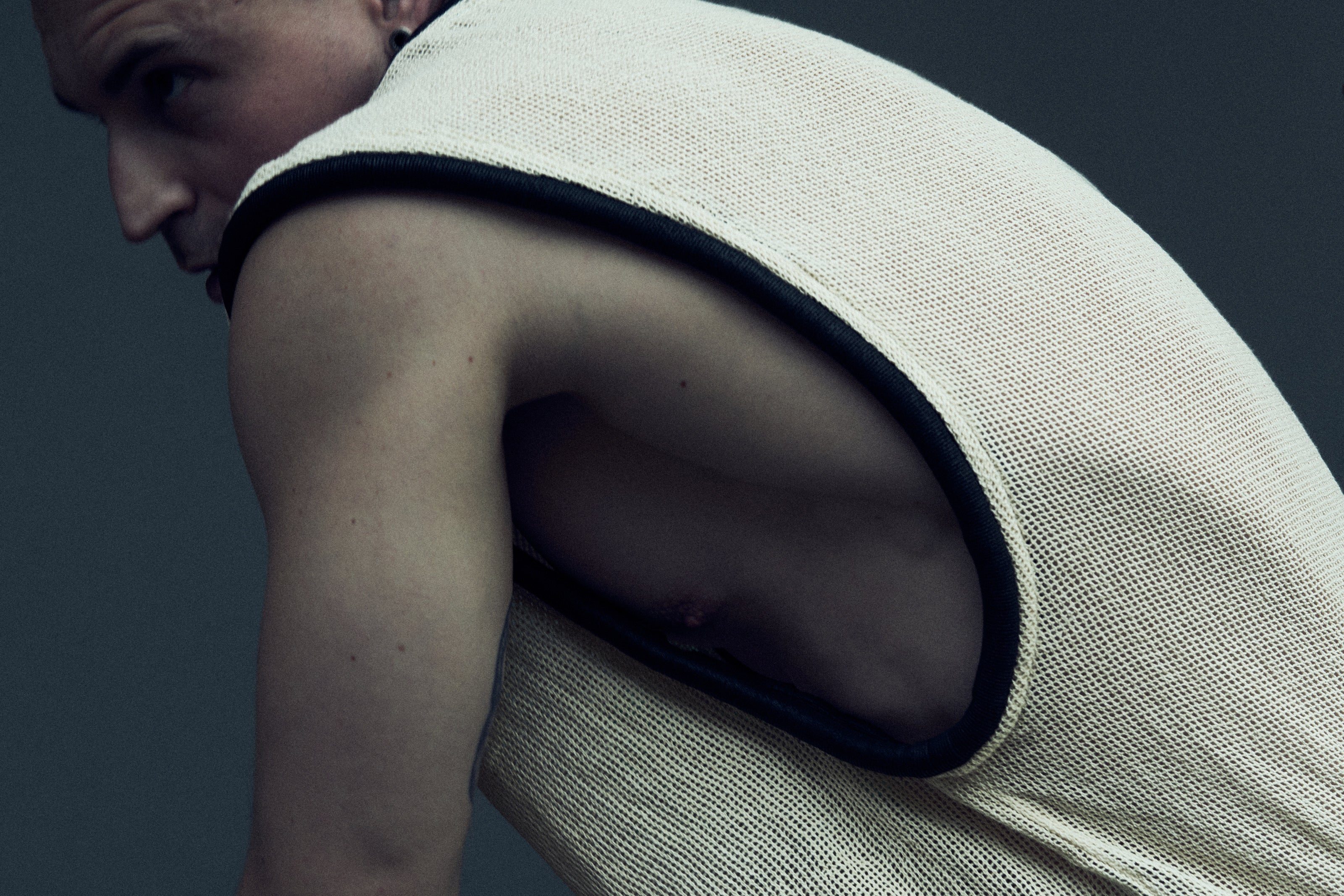 Detail of the white EIDOS-212 mesh tank top and rounded black armhole piping.