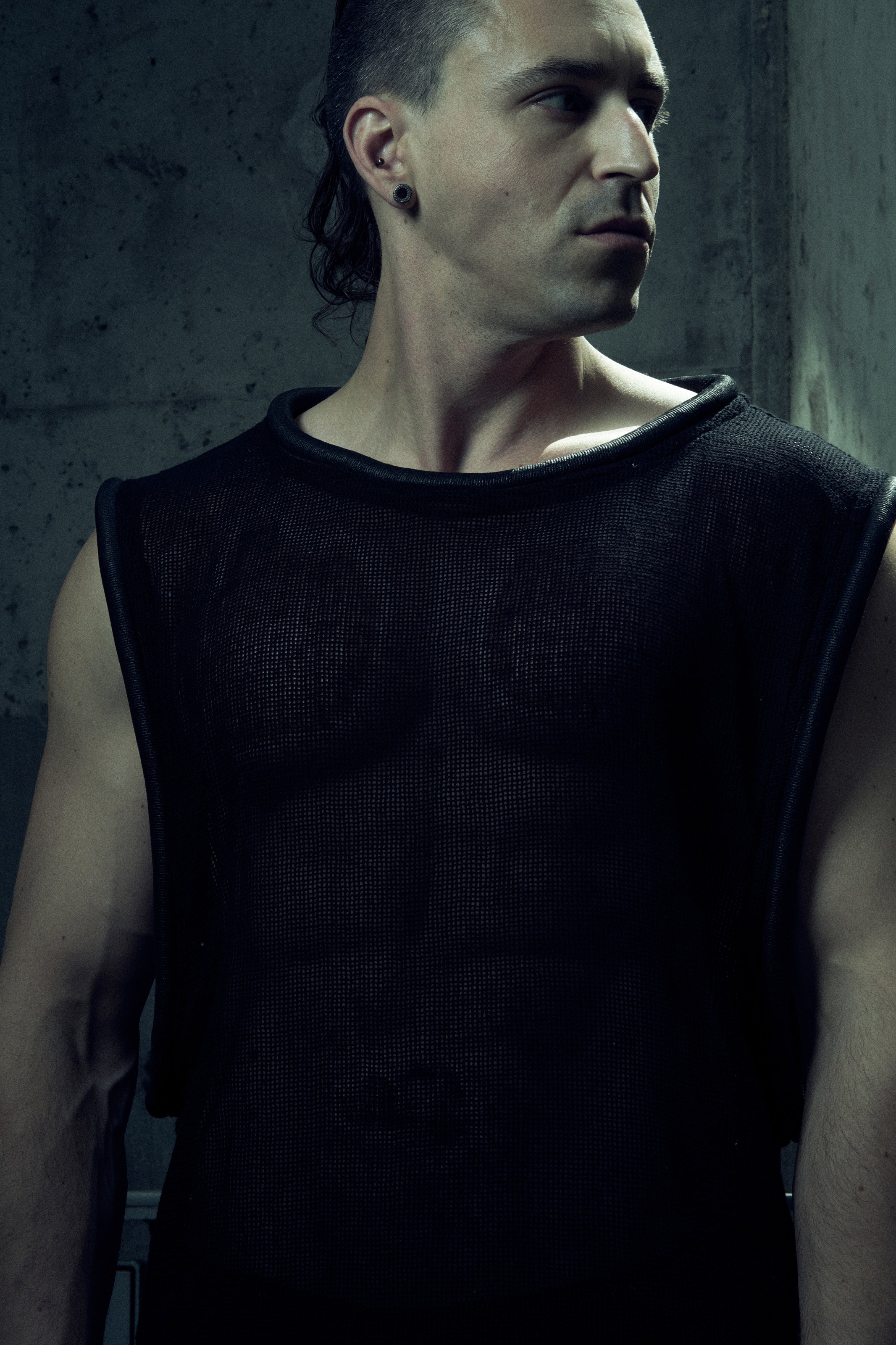 Black SYZMIC EIDOS-212 mesh tank top, front portrait looking to the side.