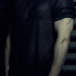 Front detail of the black EIDOS-213 organic cotton mesh T-shirt and wax-coated rib sleeve trim.