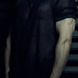 Front detail of the black EIDOS-213 organic cotton mesh T-shirt and wax-coated rib sleeve trim.