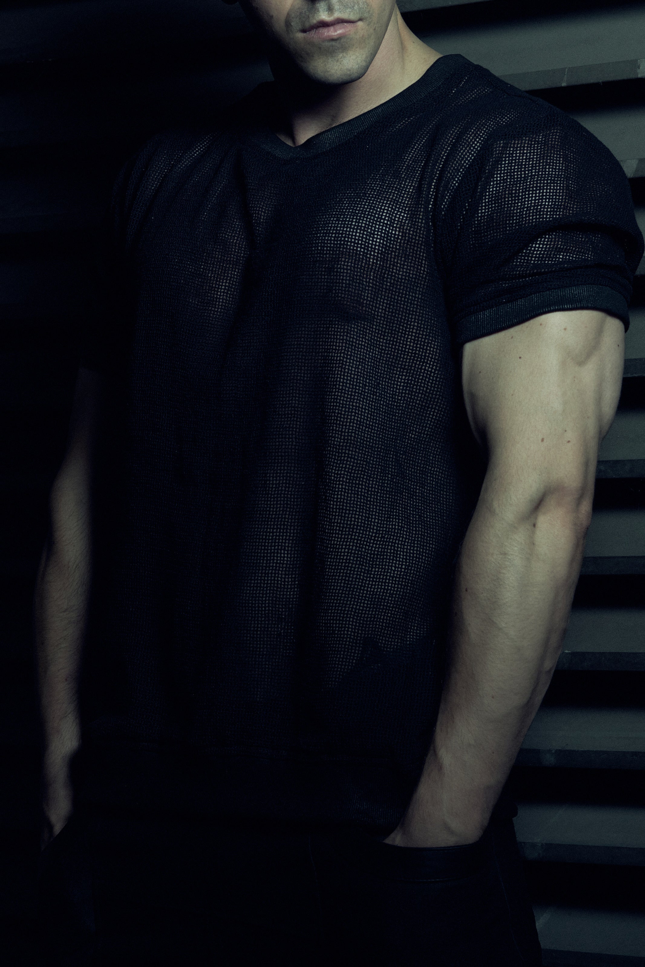 Front detail of the black EIDOS-213 organic cotton mesh T-shirt and wax-coated rib sleeve trim.