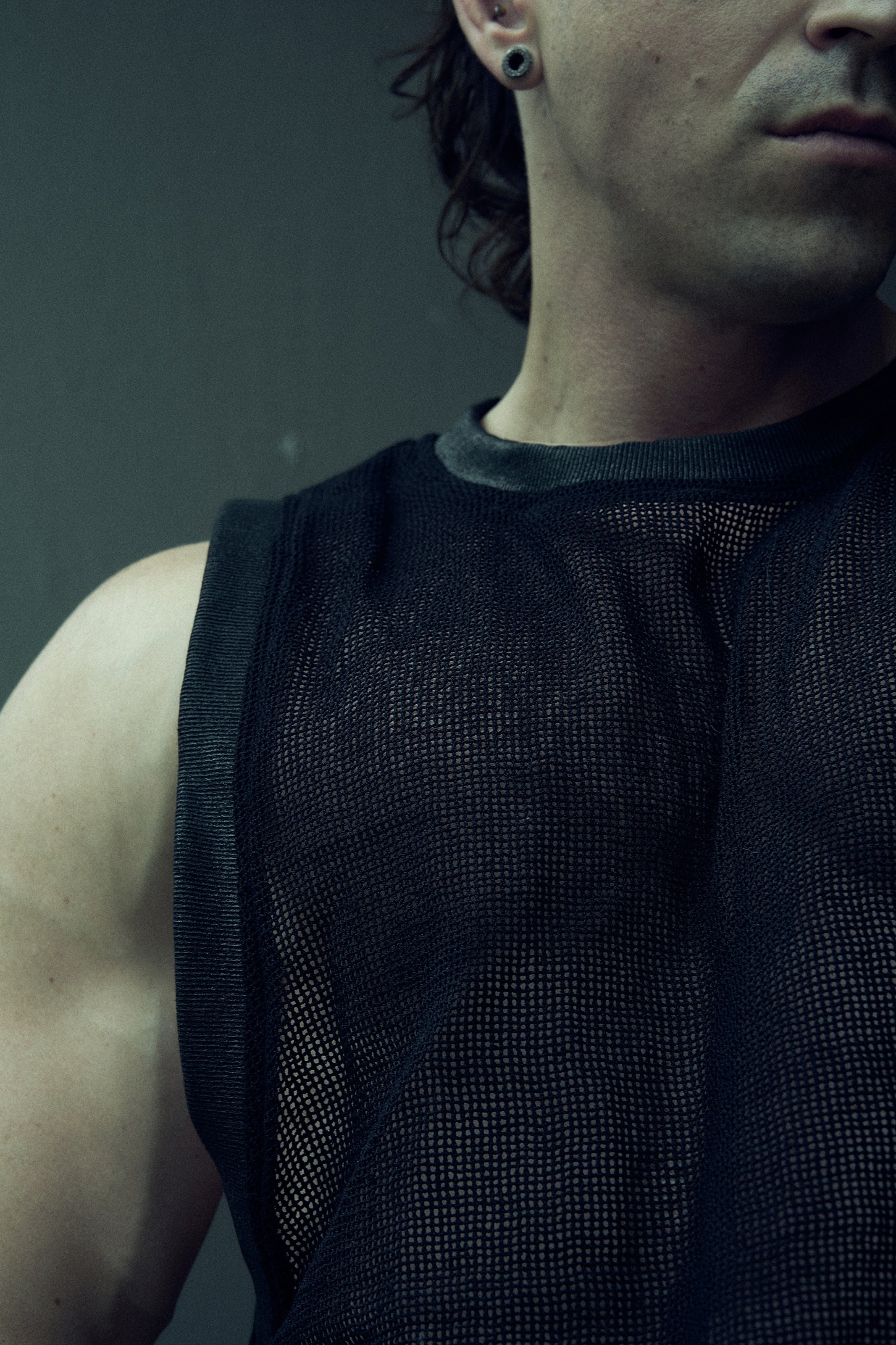 Close-up of the black EIDOS-214 tank top showing the round rib neckline and organic cotton mesh.