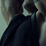 Black SYZMIC EIDOS-214 mesh tank top, close-up with the model’s arms raised.
