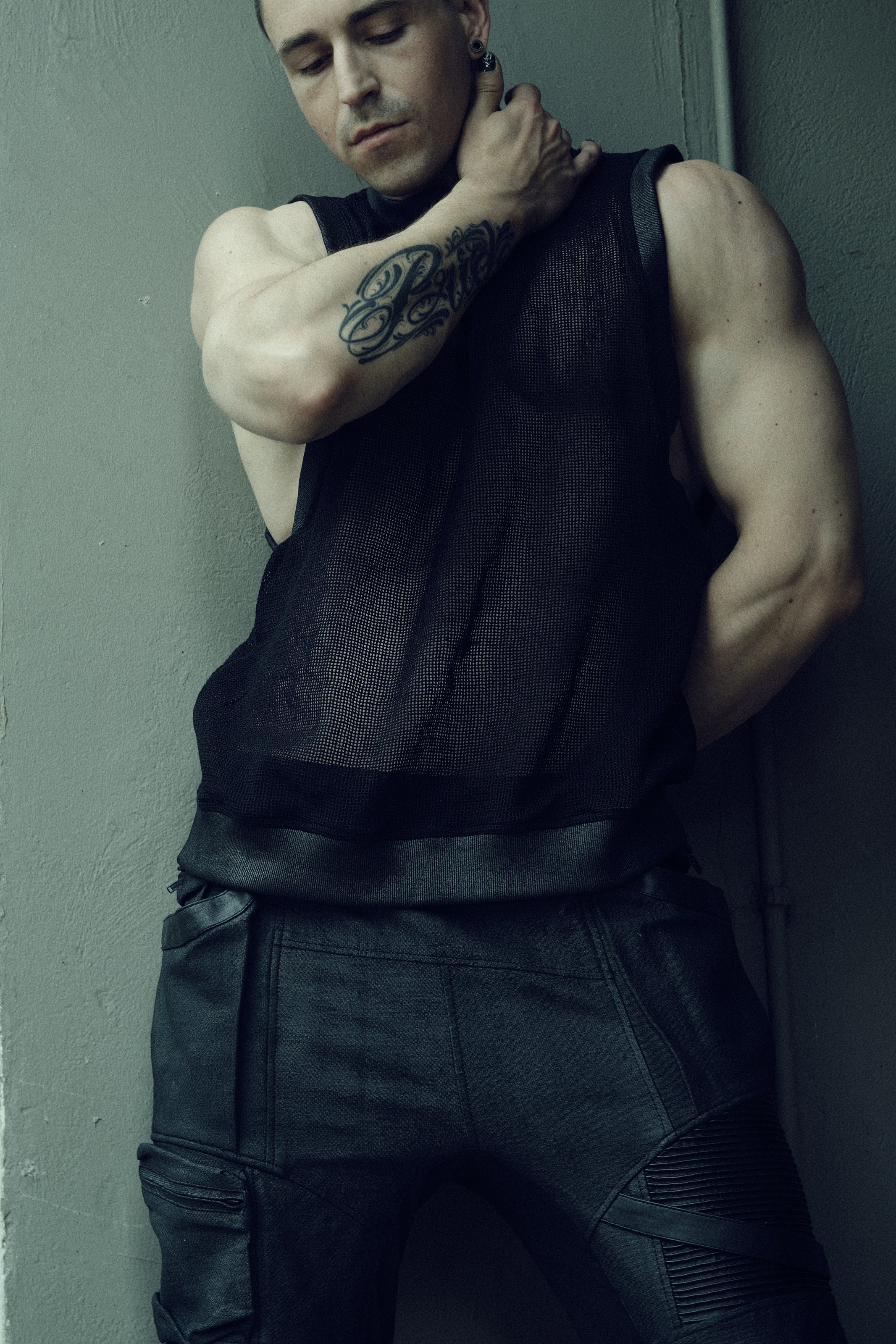 Black SYZMIC EIDOS-214 tank top, front view with the model’s hand at the neck.