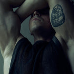 Black SYZMIC EIDOS-214 mesh tank top, close-up of the front with both arms raised.