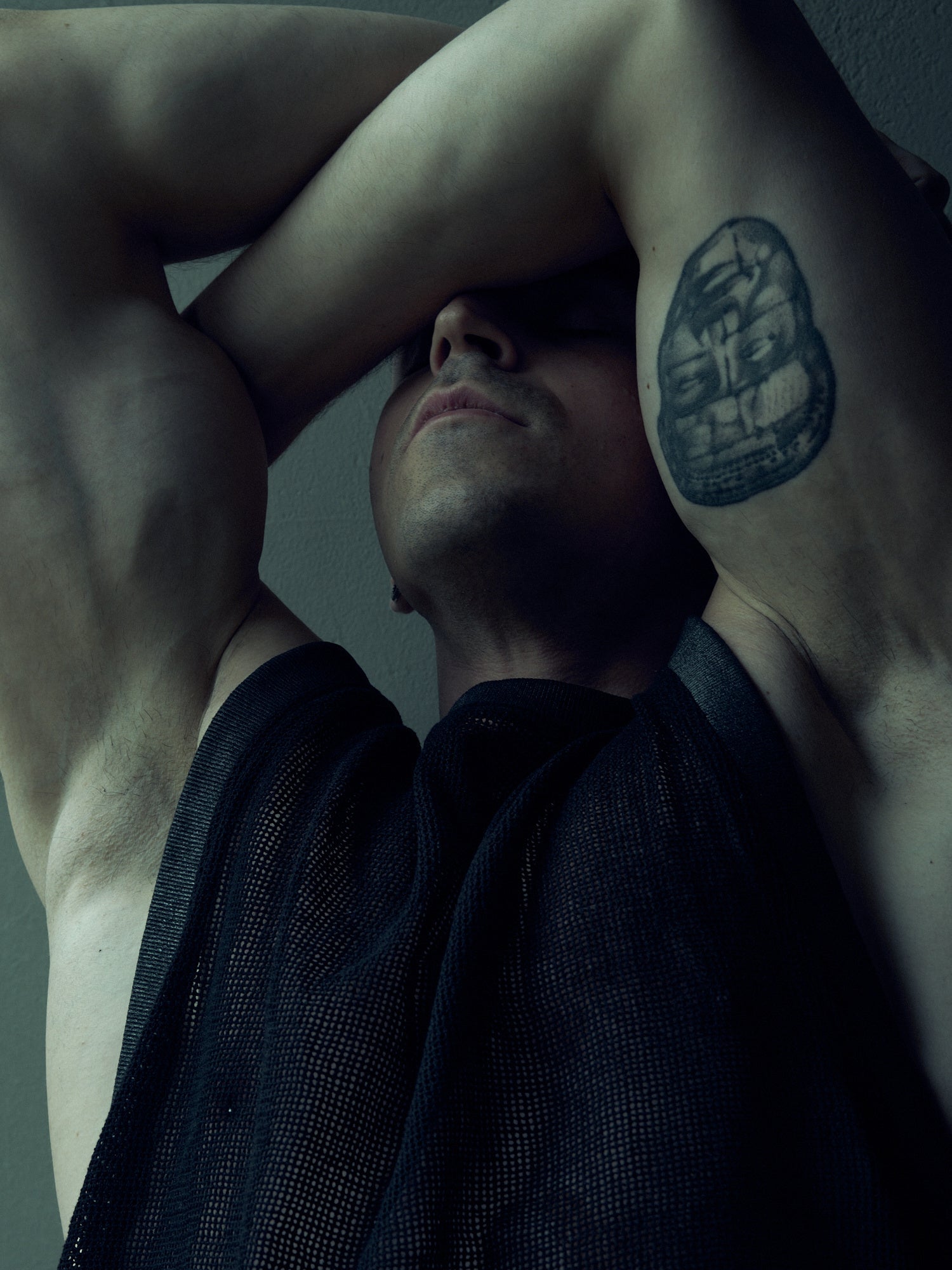 Black SYZMIC EIDOS-214 mesh tank top, close-up of the front with both arms raised.