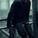 Black SYZMIC EIDOS-215 long-sleeve top worn beside a metal railing, front three-quarter view.