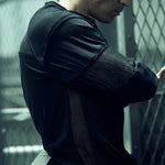 Side view of the black SYZMIC EIDOS-215 long-sleeve top and textured sleeve panels.