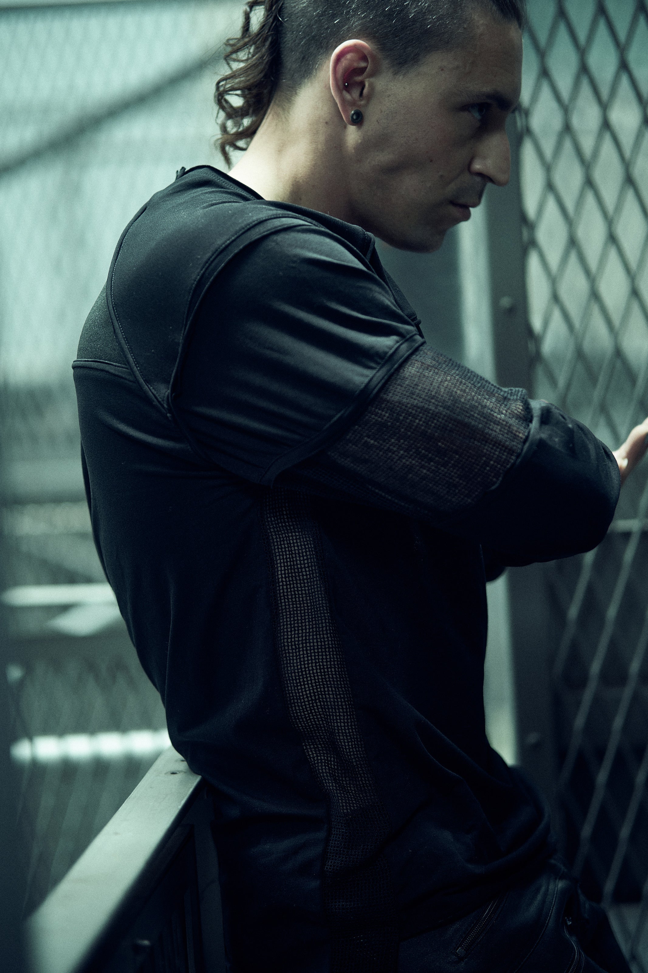 Side view of the black SYZMIC EIDOS-215 long-sleeve top and textured sleeve panels.