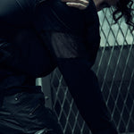 Close-up of the textured sleeve and shoulder panels on the black EIDOS-215 long-sleeve top.