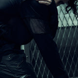 Close-up of the textured sleeve and shoulder panels on the black EIDOS-215 long-sleeve top.