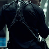 Rear view of the black SYZMIC EIDOS-215 long-sleeve top worn beneath a backpack.