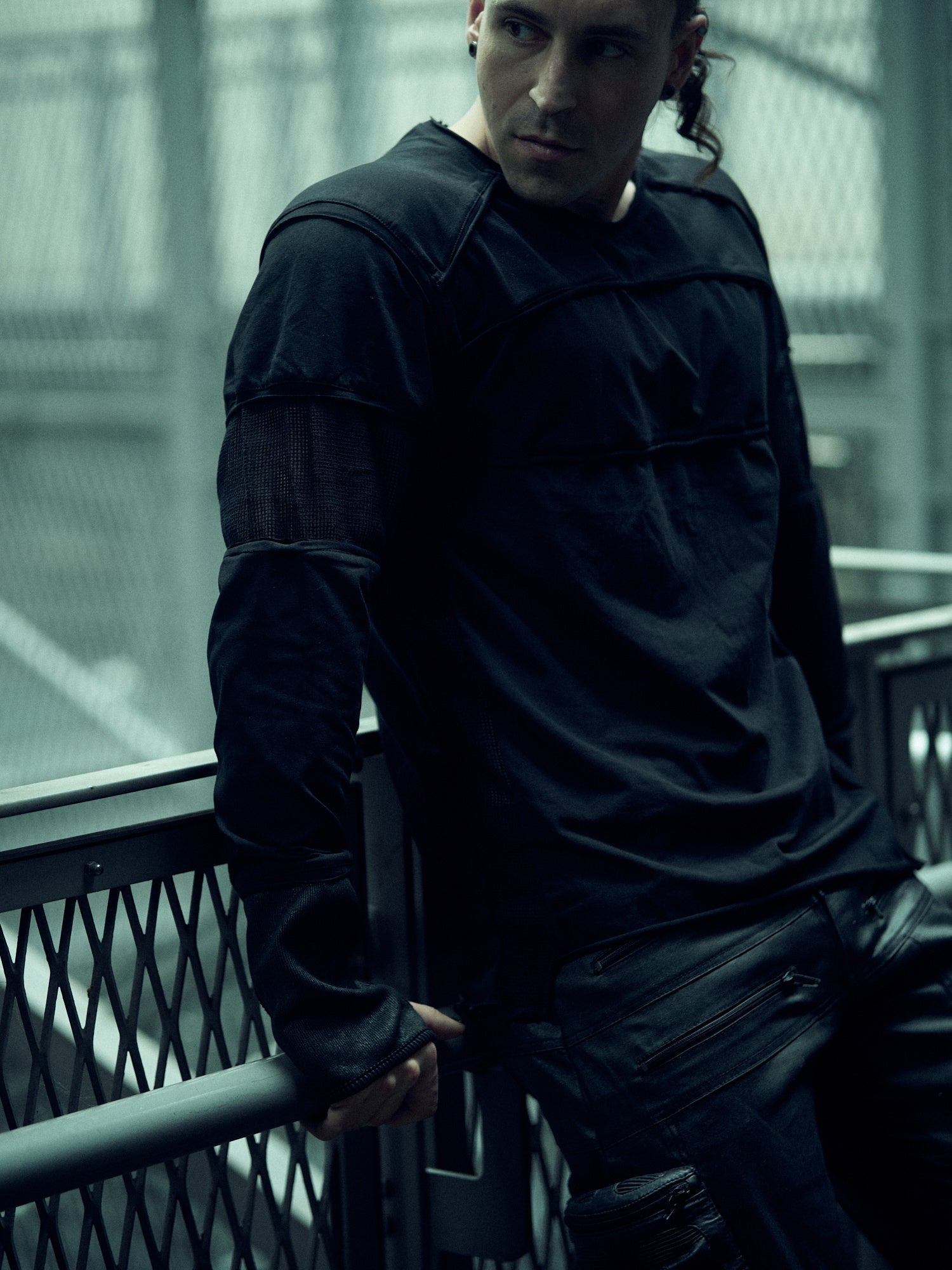 Front view of the black SYZMIC EIDOS-215 long-sleeve top, worn with black trousers.