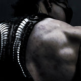 Rear close-up of Flo wearing the black SYZMIC HYLO-501 leather holster bag, showing its sculpted vertebral back panel. Photography by Lazar.