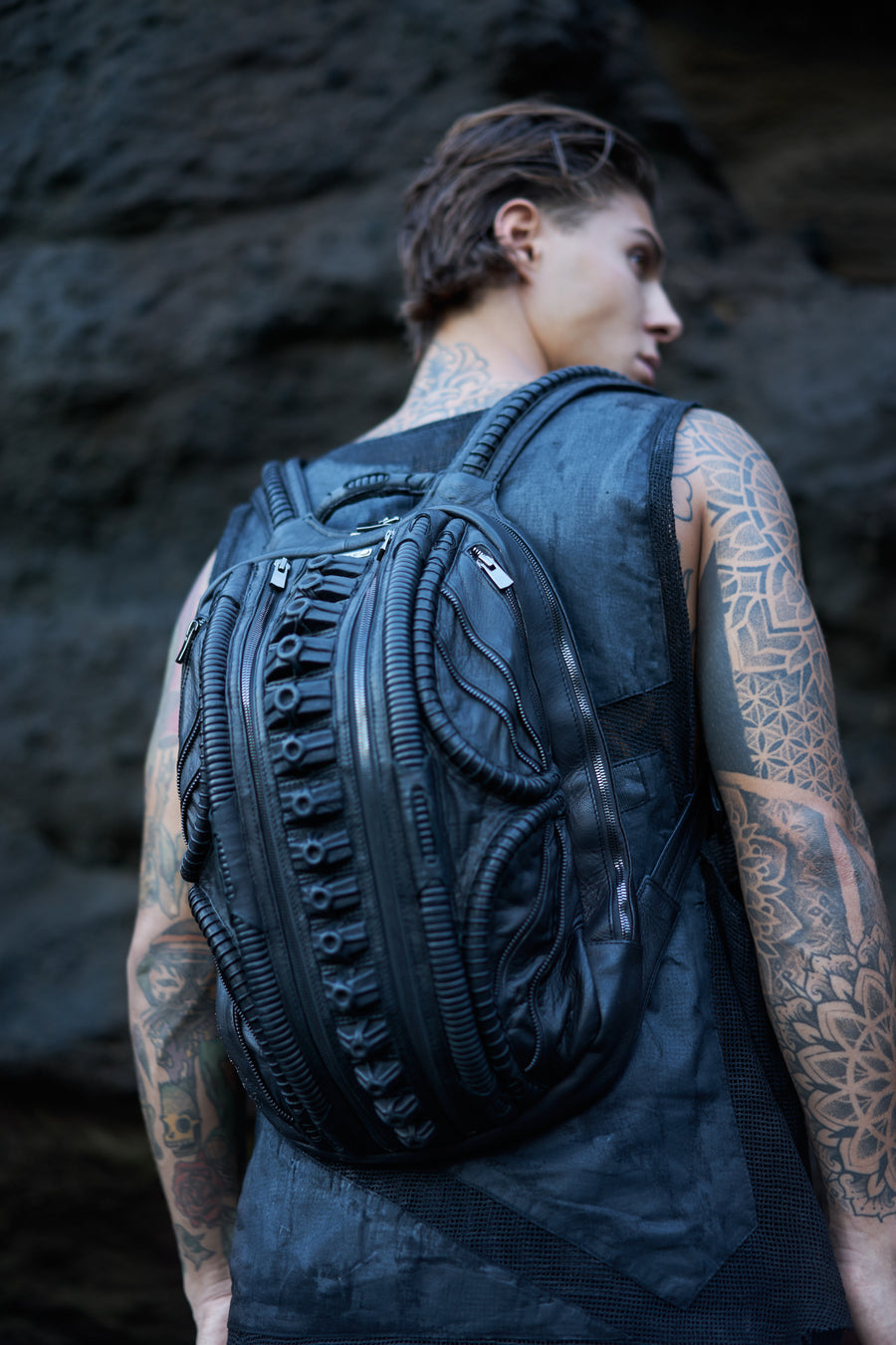 avant-garde leather backpack with biomorphic alien design aesthetic in post-apocalyptic dark fashion